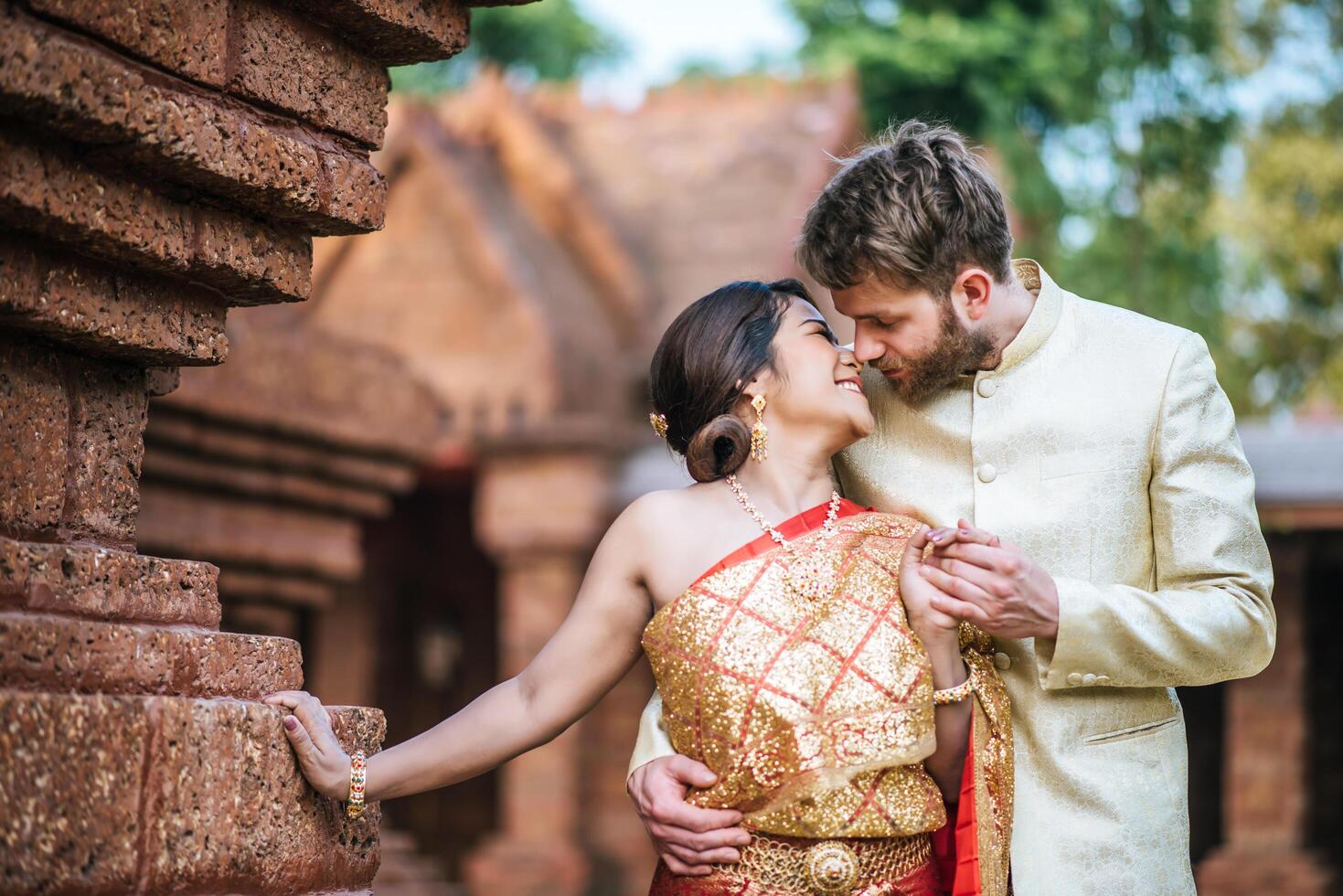 La novia asiática y el novio caucásico tienen tiempo romántico con el vestido de Tailandia foto