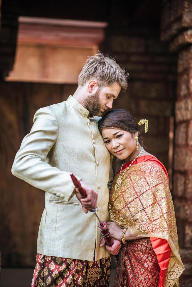 Asian bride and Caucasian groom have romantic time with Thailand dress photo