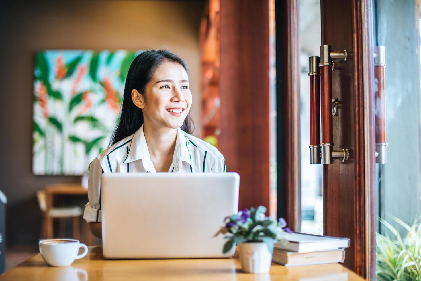 Bella mujer trabajando con ordenador portátil en la cafetería cafe foto