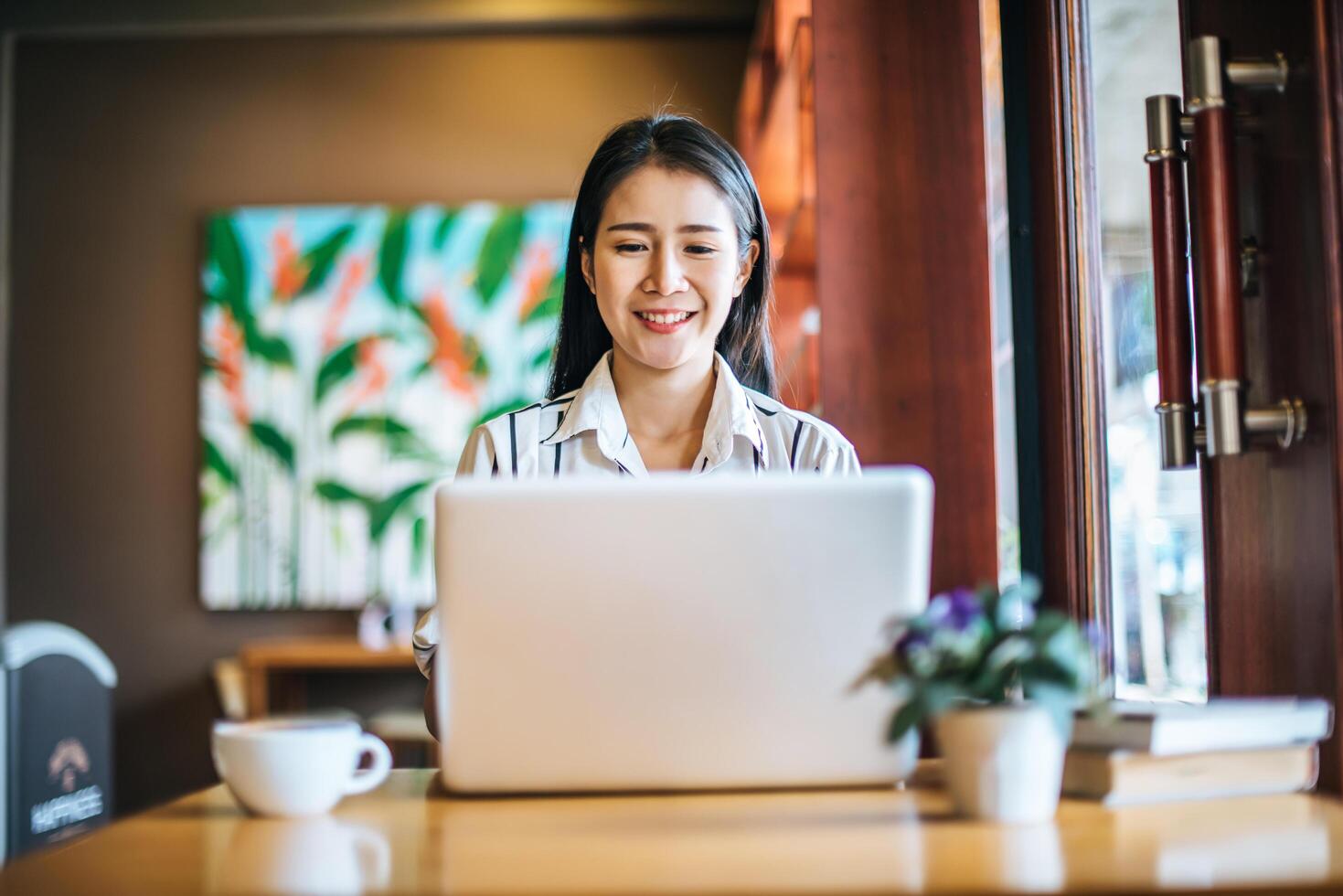 Bella mujer trabajando con ordenador portátil en la cafetería cafe foto