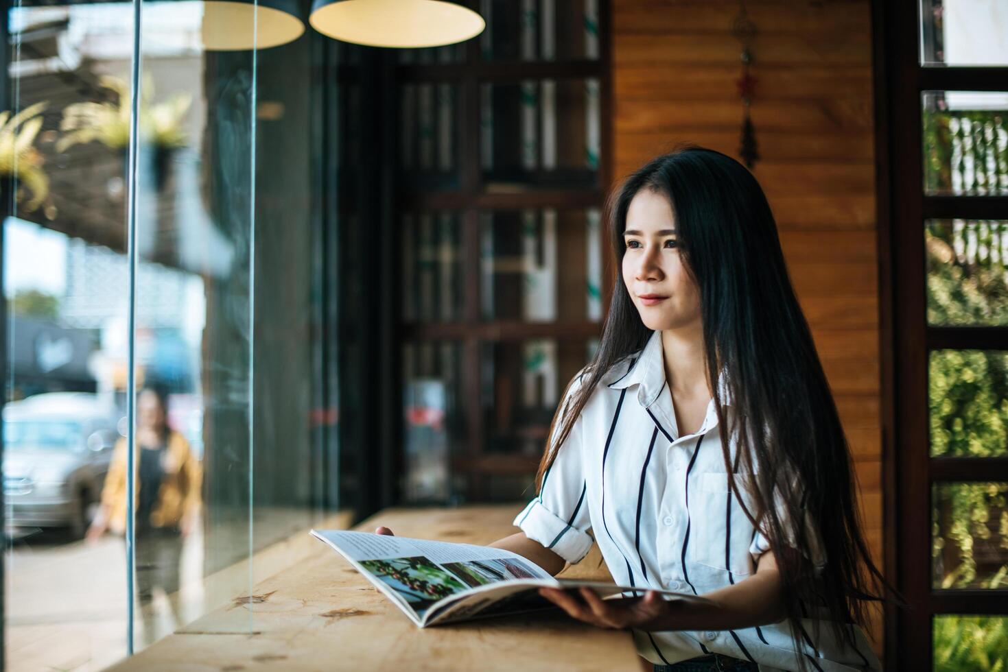 Hermosa mujer leyendo una revista en el café foto