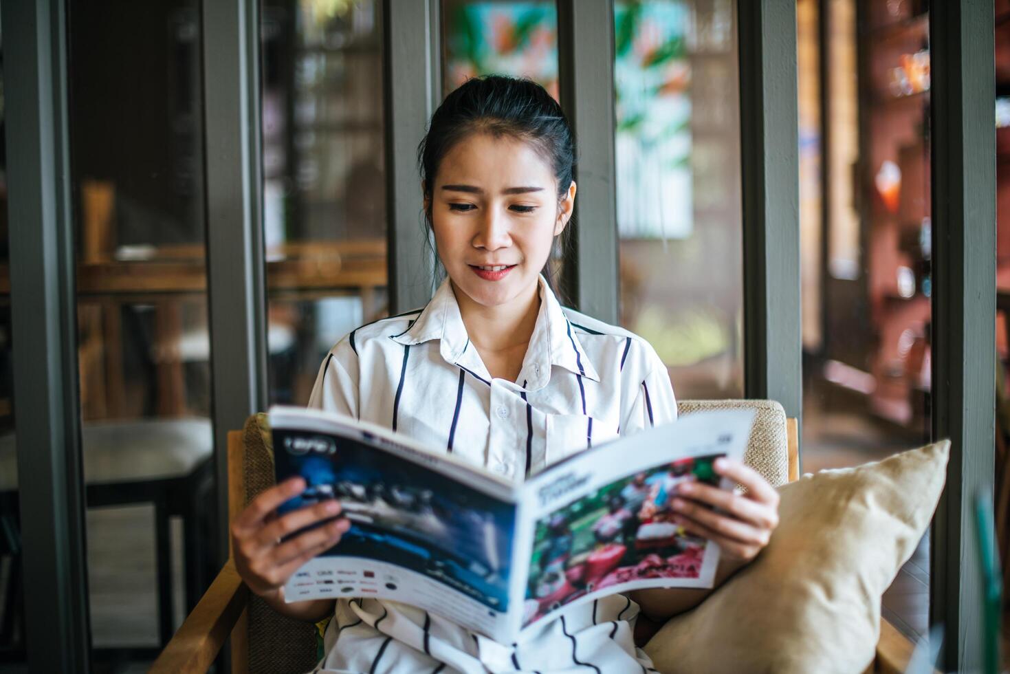 Beautiful woman reading magazine in cafe photo