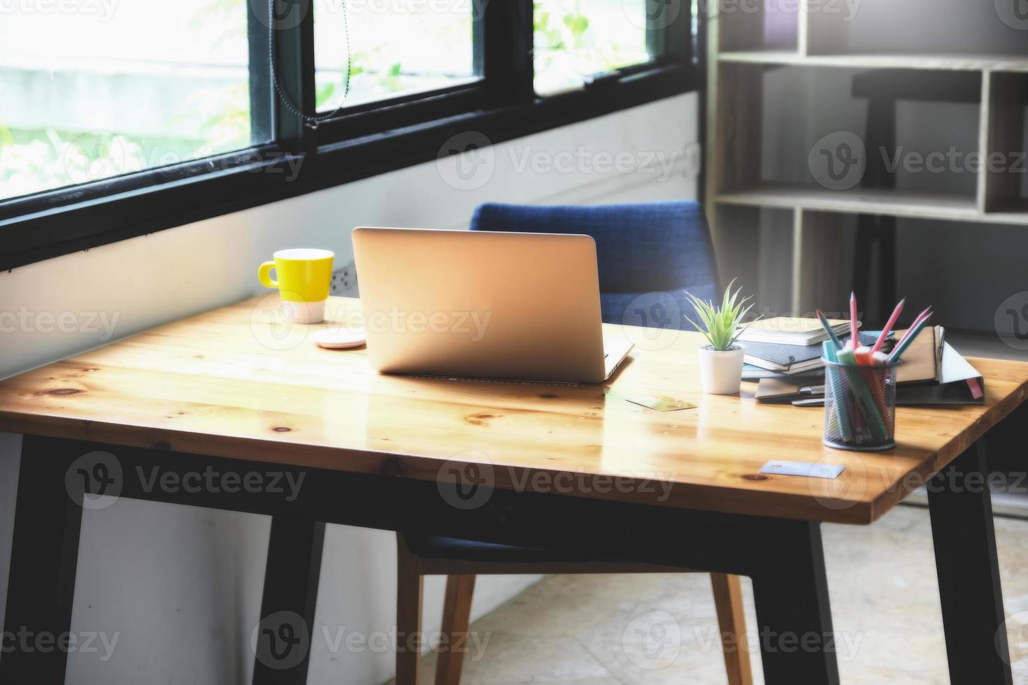 focus computer laptop with notebook and document on wood desk at home, vintage effect. photo