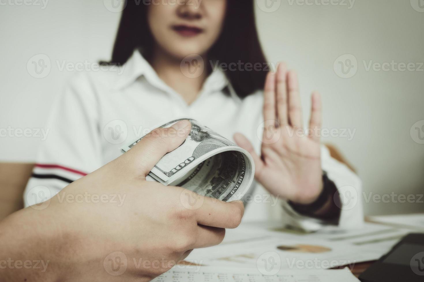 enfoque mano sosteniendo dinero, el auditor muestra un gesto de negarse a recibir dinero del soborno del oficial. foto