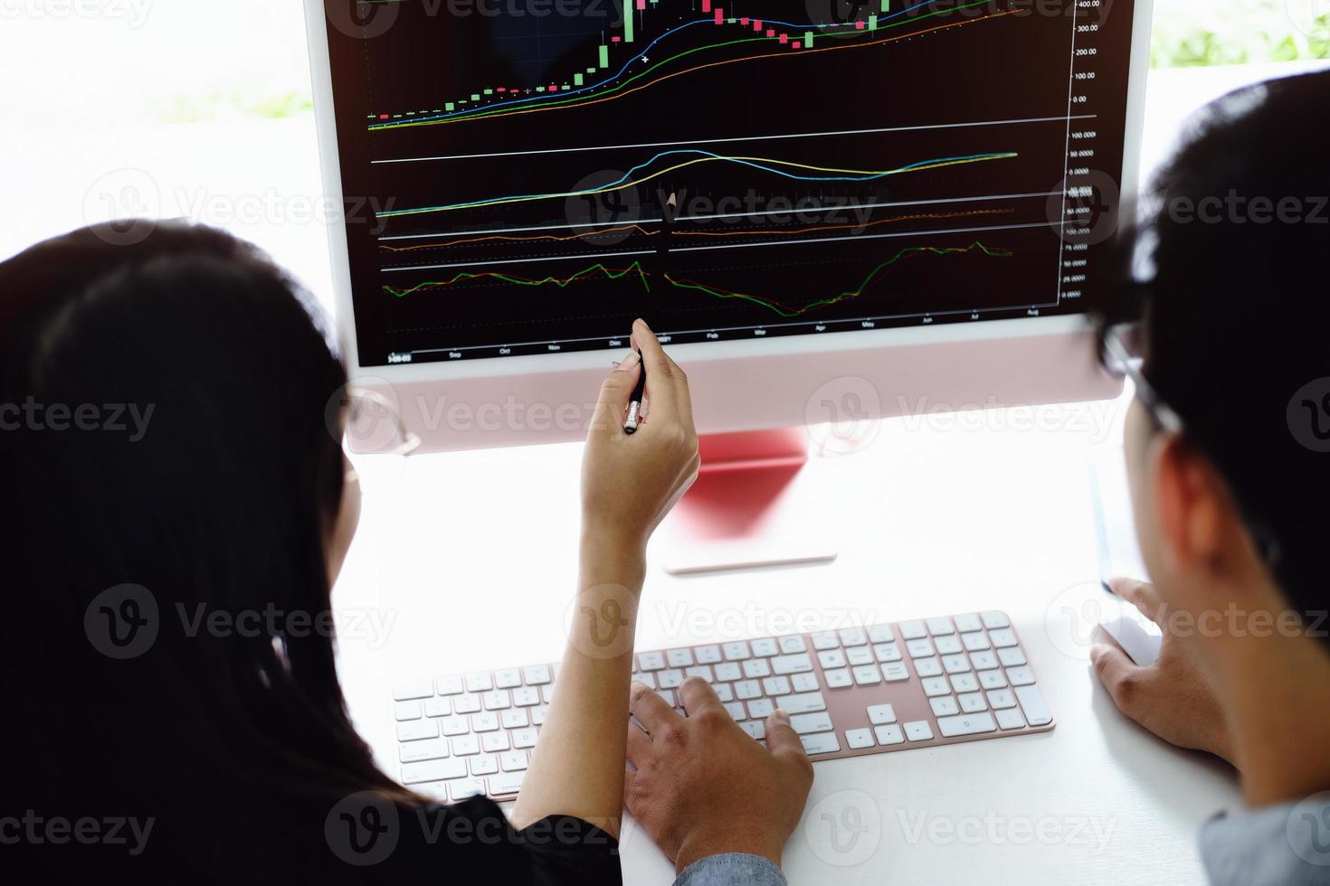 An investment expert points a pen at a tablet monitor to analyze the stock market to teach you how to make a profit. photo