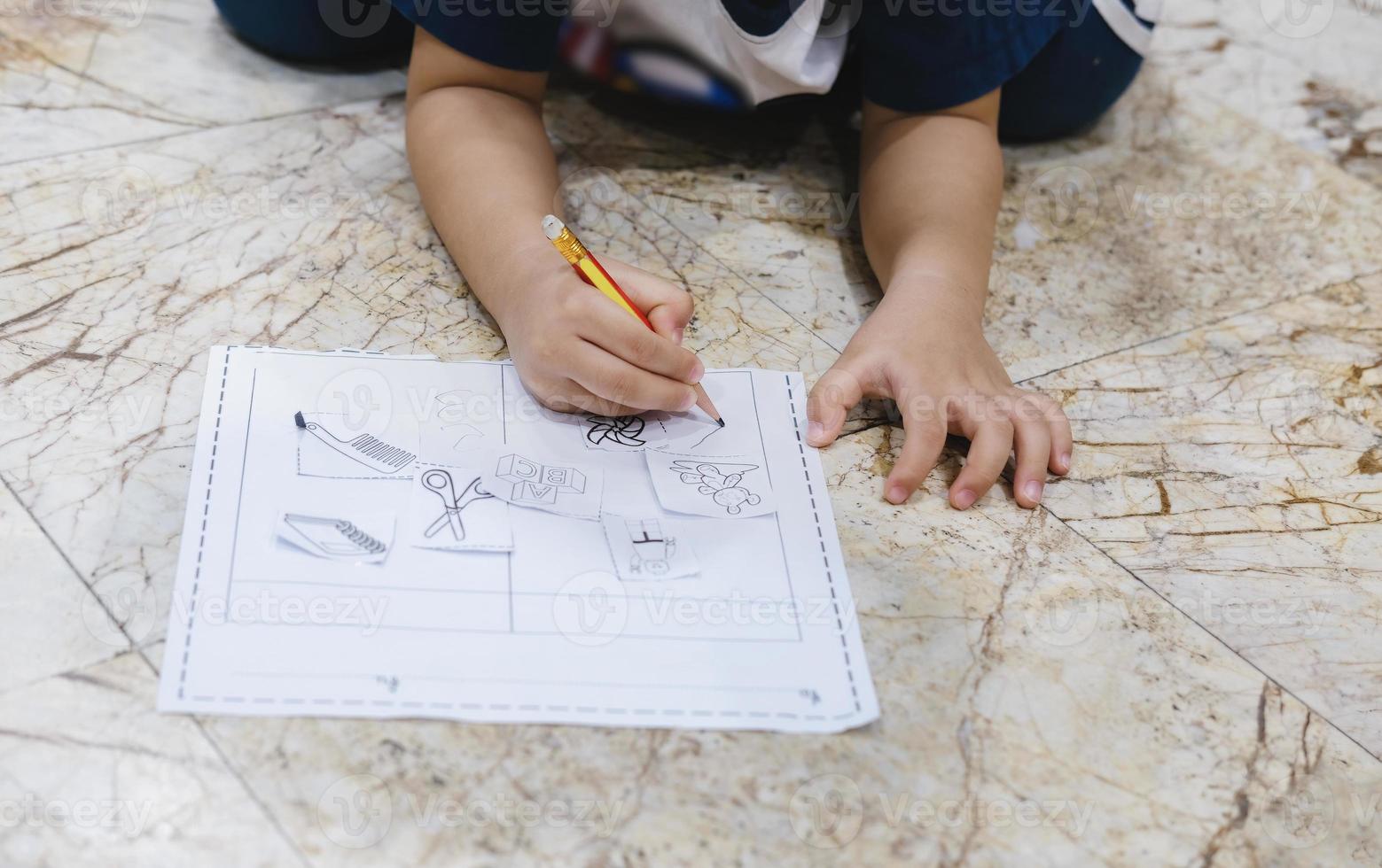 infancia aprendiendo a usar un lápiz para dibujar y escribir en papel. foto