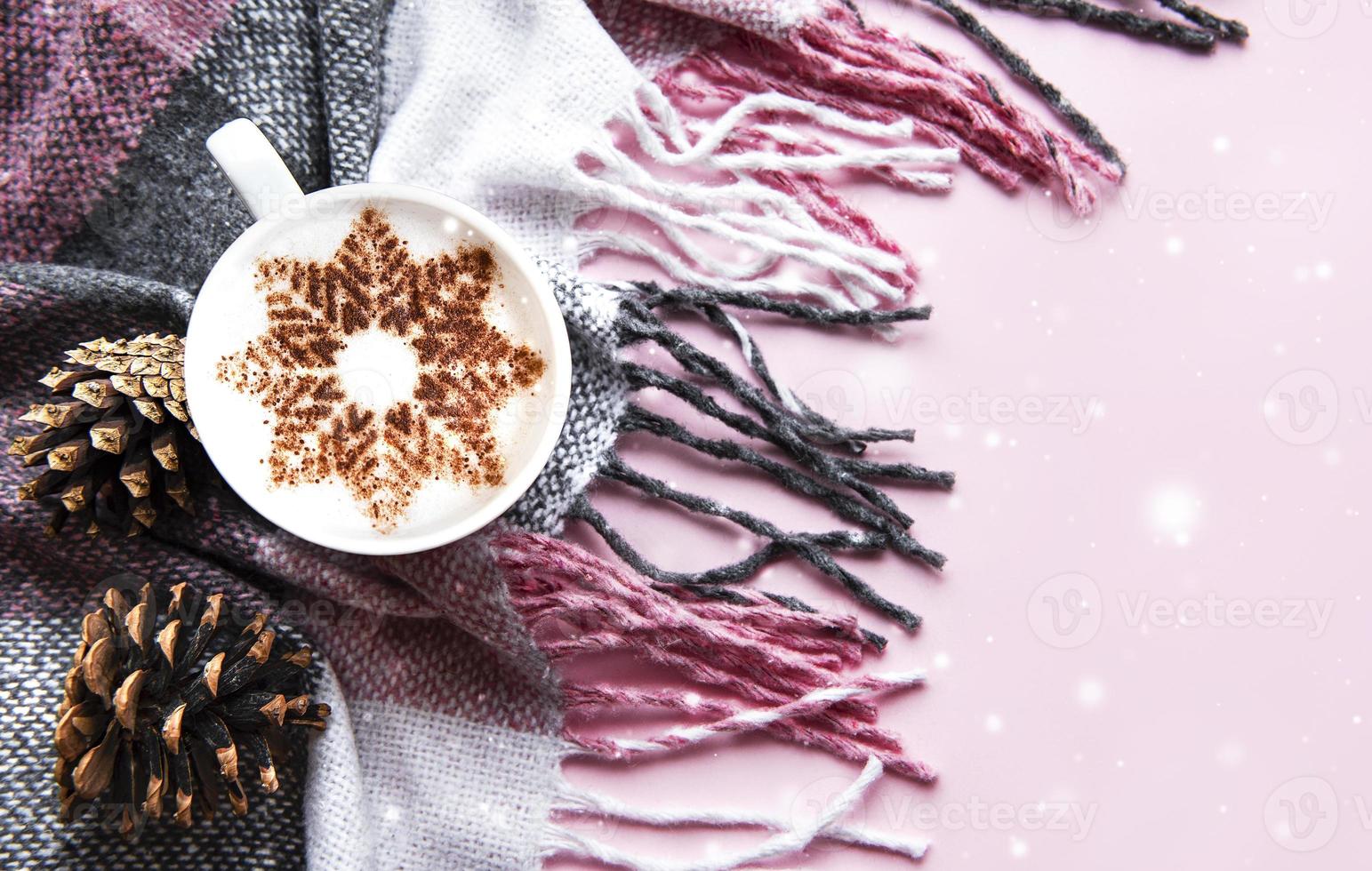 Coffee with a snowflake pattern on a warm woolen plaid photo