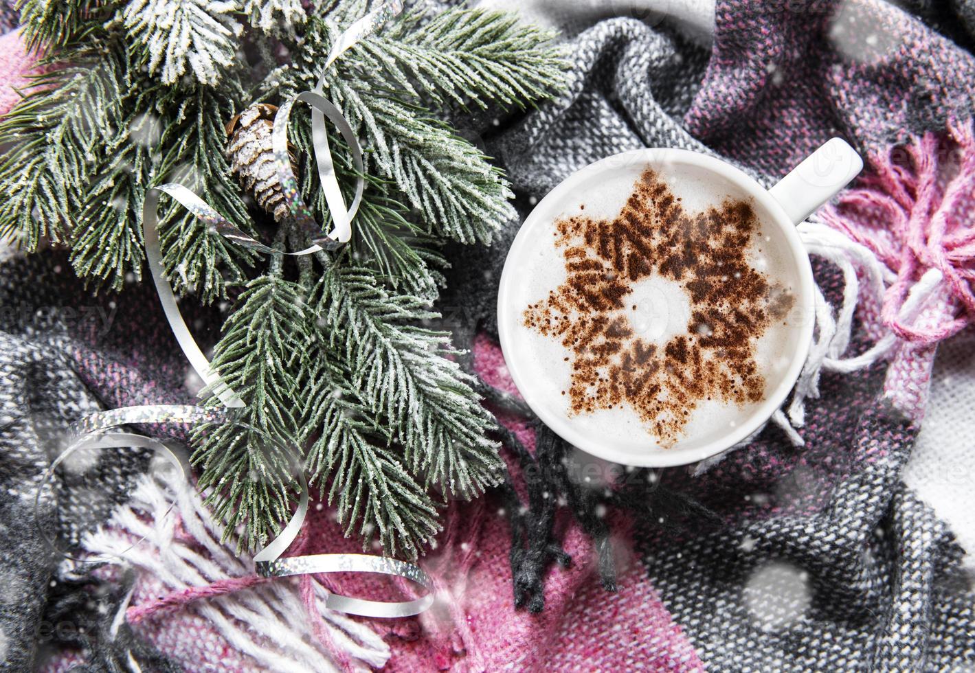 Coffee with a snowflake pattern on a warm woolen plaid photo