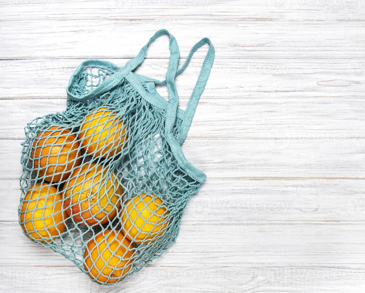 bolso de compras de malla con naranjas foto