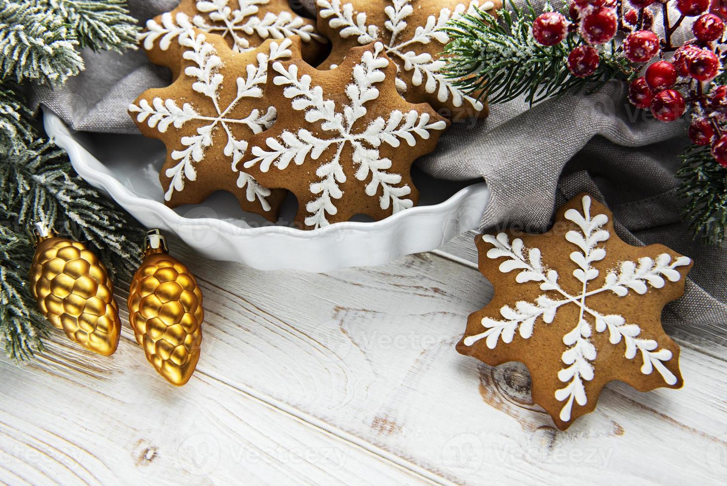 Tazón de galletas de Navidad de jengibre en rústica mesa de madera blanca foto