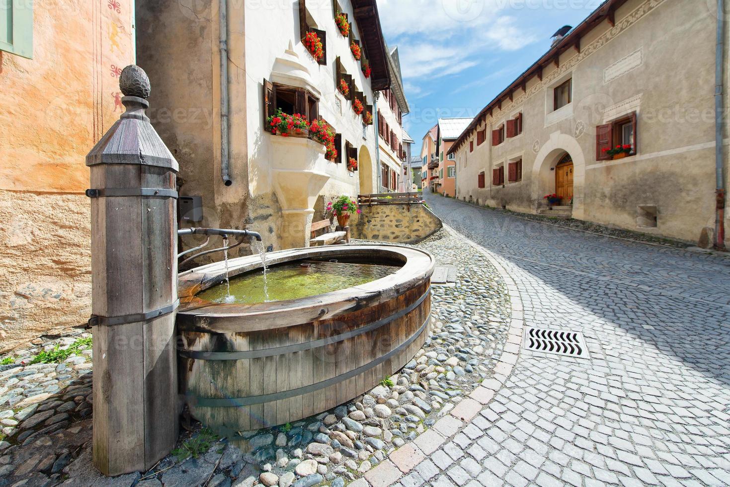 Old fountain in the Swiss Alpine village of Guarda in the Engadi photo