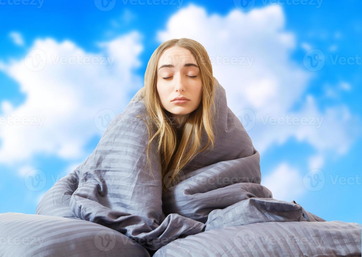 imagen creativa niña mujer en la cama después de dormir en el fondo del cielo aislado, dormir mujer, quedarse en casa concepto, cuarentena de coronavirus, despertar por la mañana foto