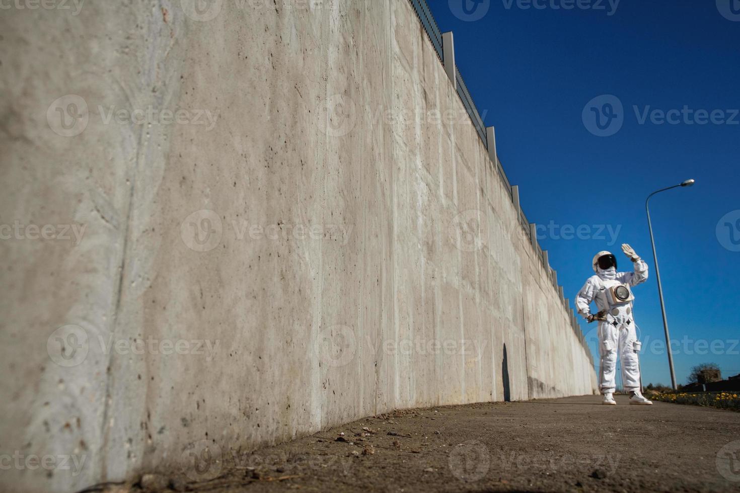 Astronauta futurista en un casco contra paredes grises foto