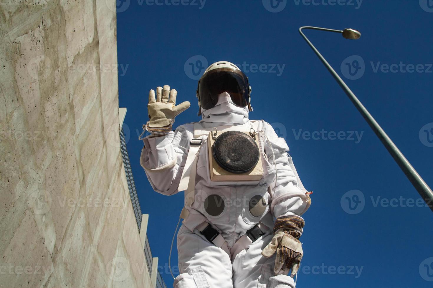 Astronauta futurista en un casco contra paredes grises foto