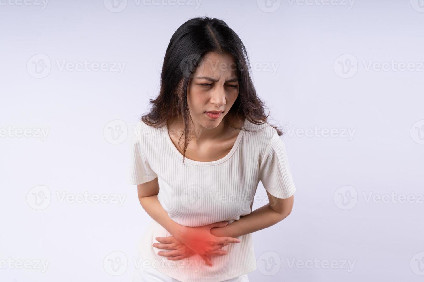 Portrait of Asian woman suffering from stomach ache isolated on white background photo