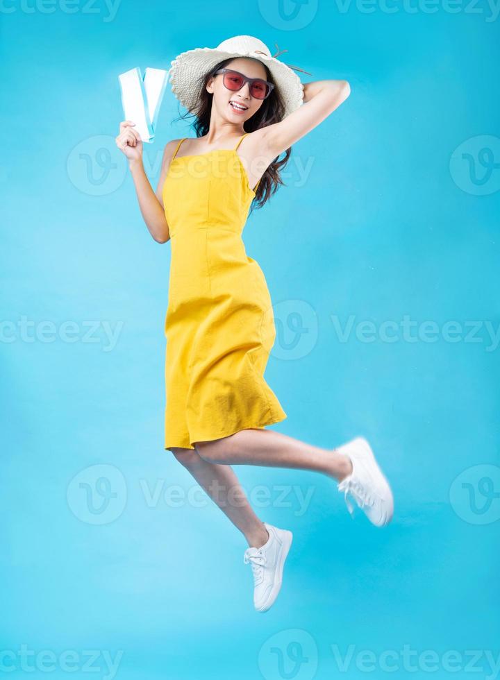 Portrait of young girl traveling, isolated on blue background photo