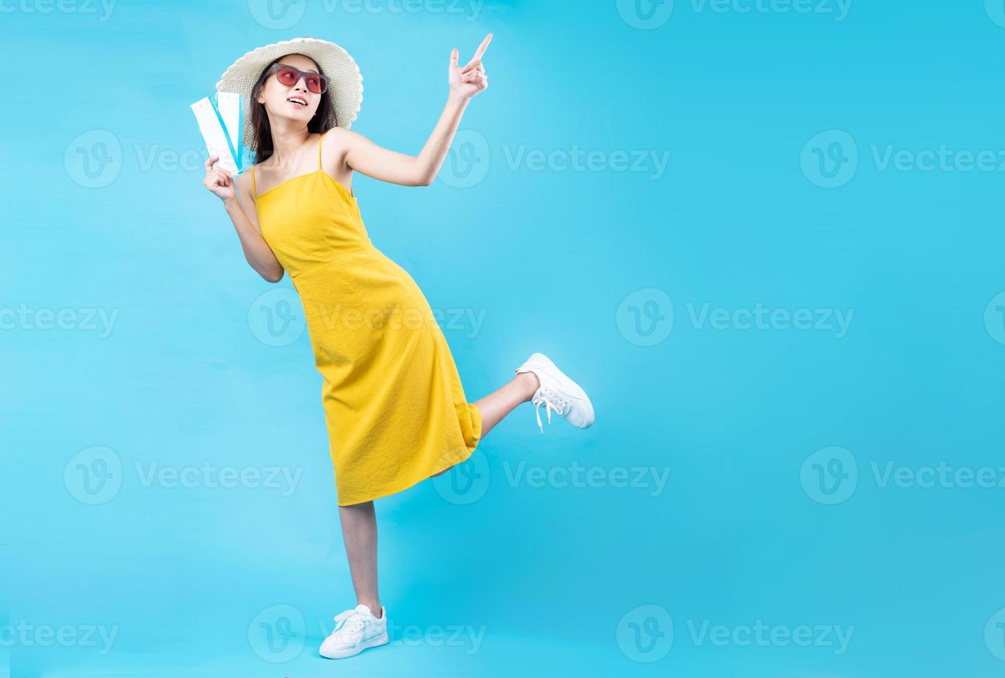 Portrait of young girl traveling, isolated on blue background photo