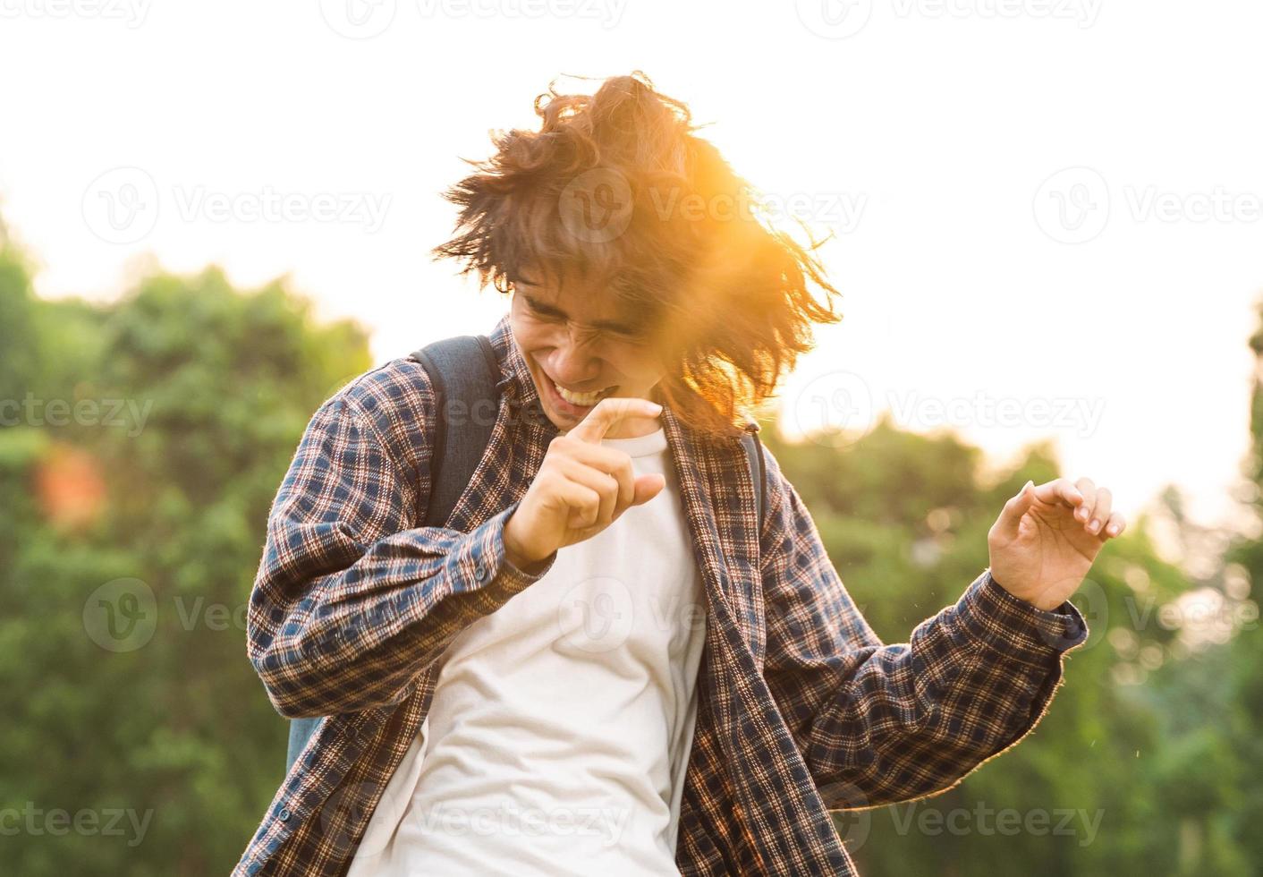 Young Asian man with long hair dancing happily photo