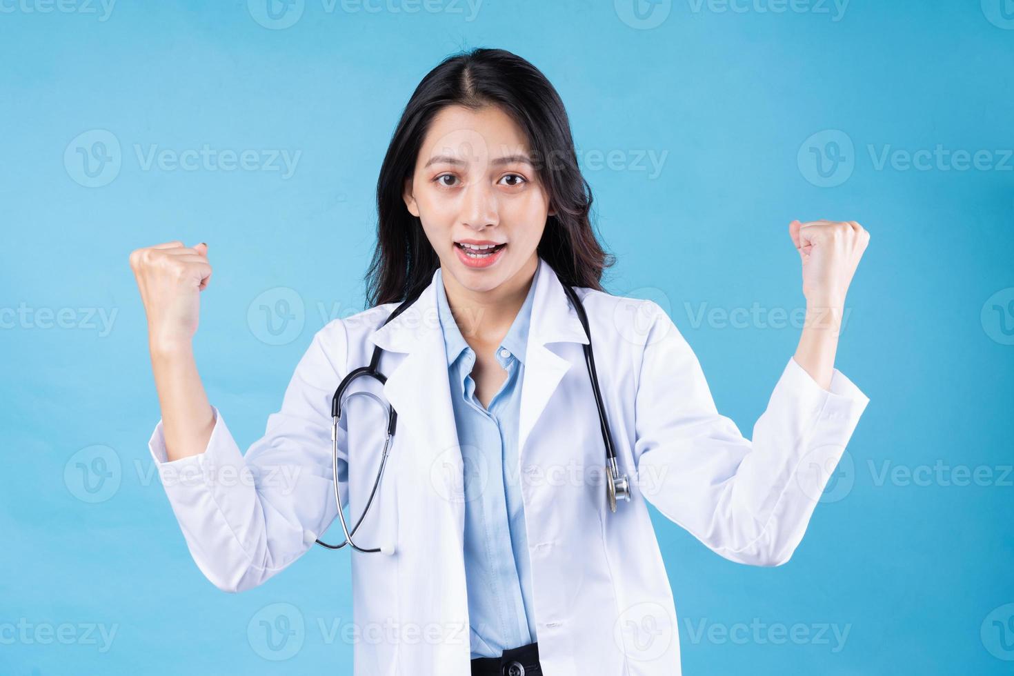 Retrato de joven doctora, aislado sobre fondo azul. foto