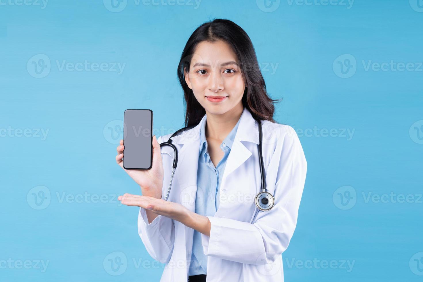 Retrato de joven doctora, aislado sobre fondo azul. foto