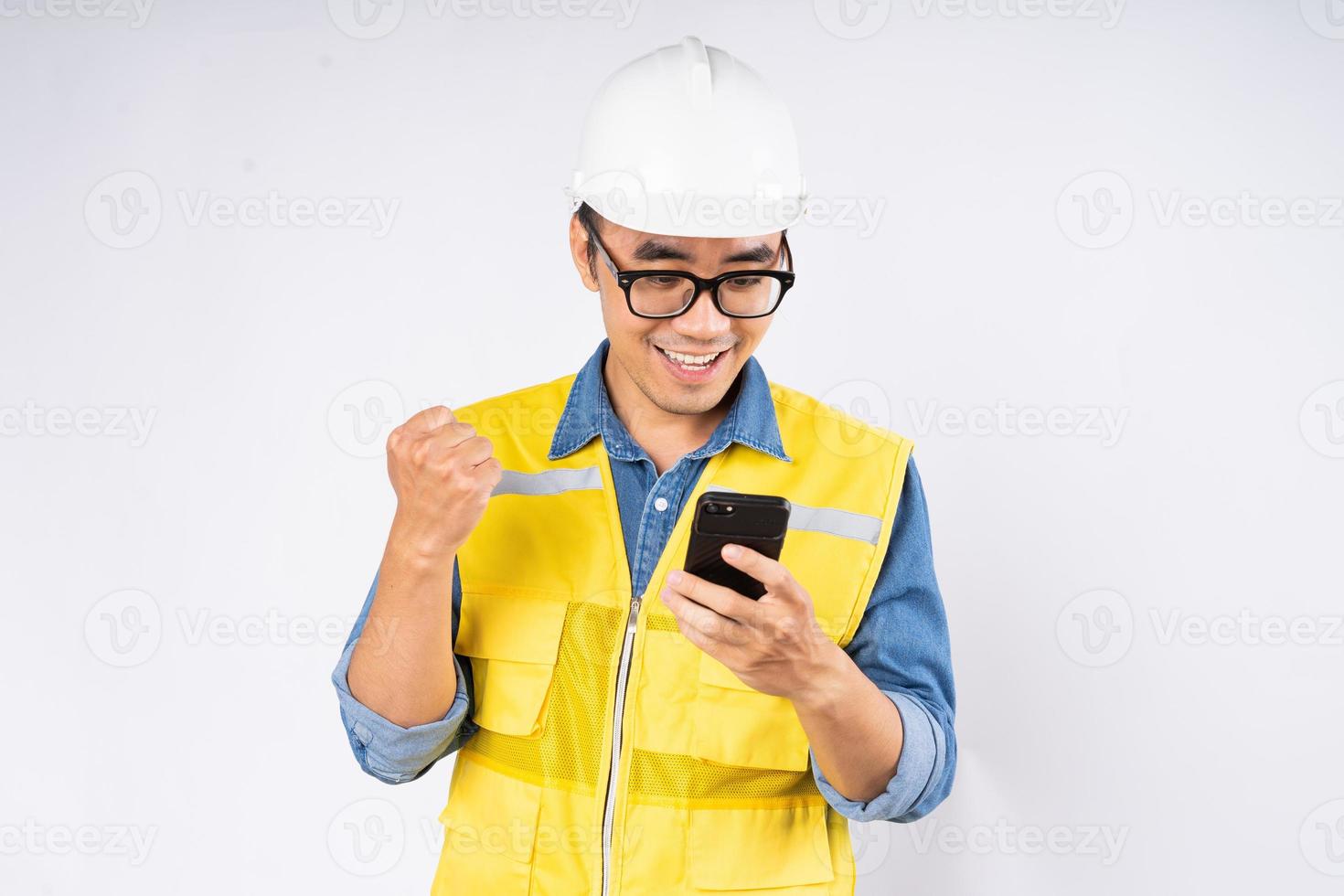 Sonriente joven ingeniero civil asiático con casco casco de pie sobre fondo blanco aislado. concepto de servicio mecánico. foto