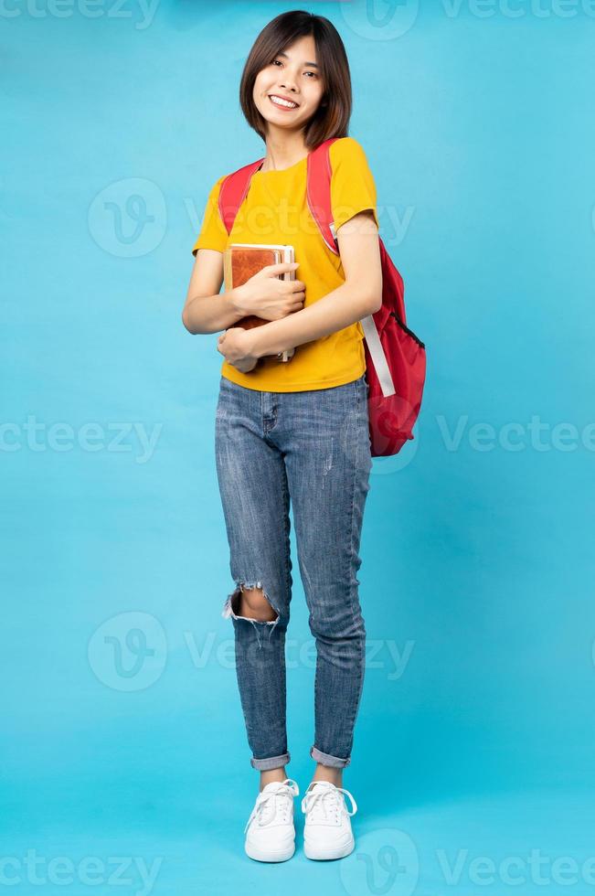 Retrato de joven estudiante, aislado sobre fondo azul. foto