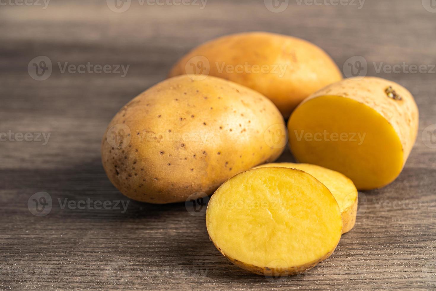 Potato raw and fresh vegetable food on wooden background. photo