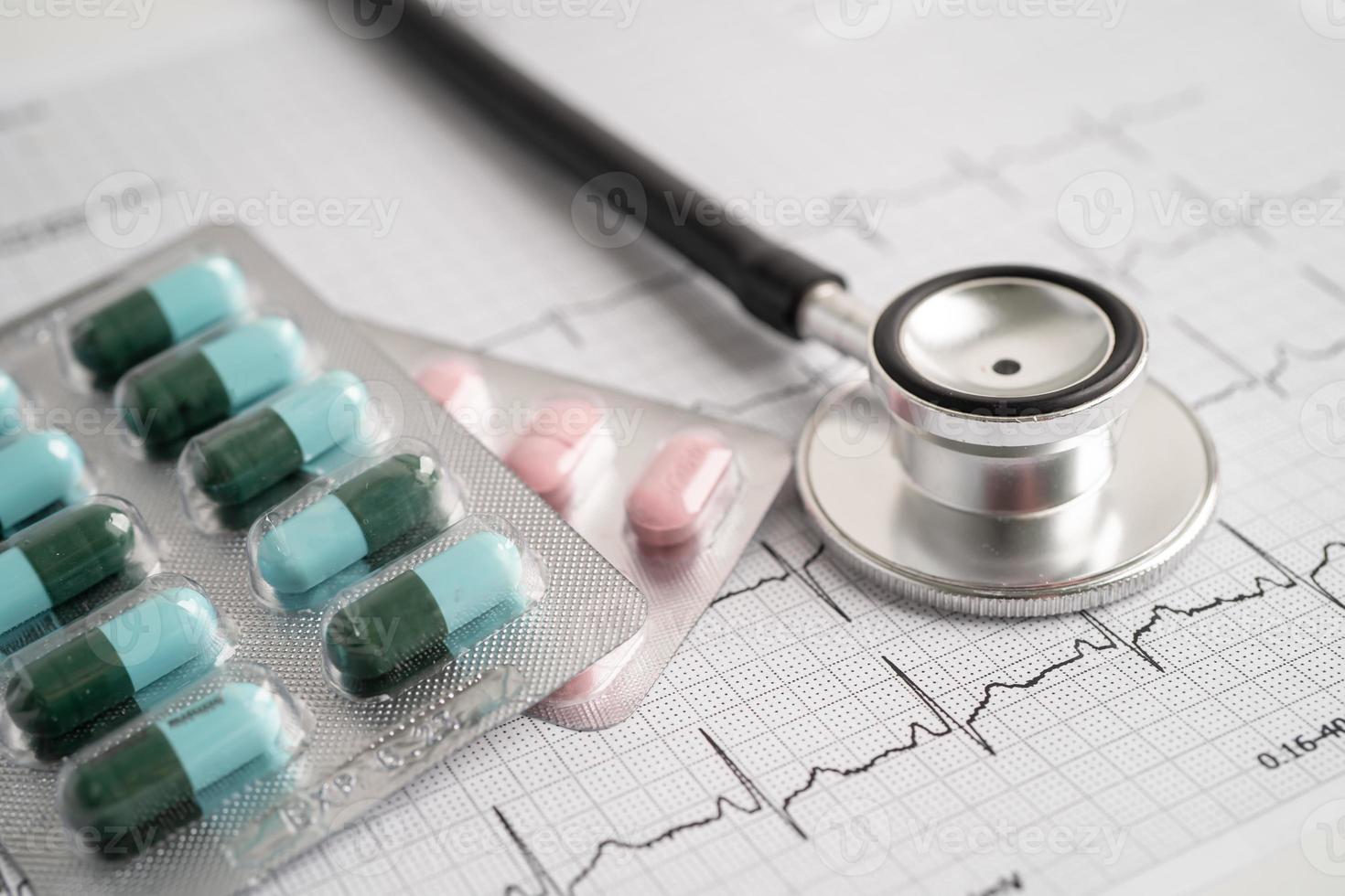 Stethoscope on electrocardiogram with capsule pill, heart wave, heart attack, cardiogram report. photo