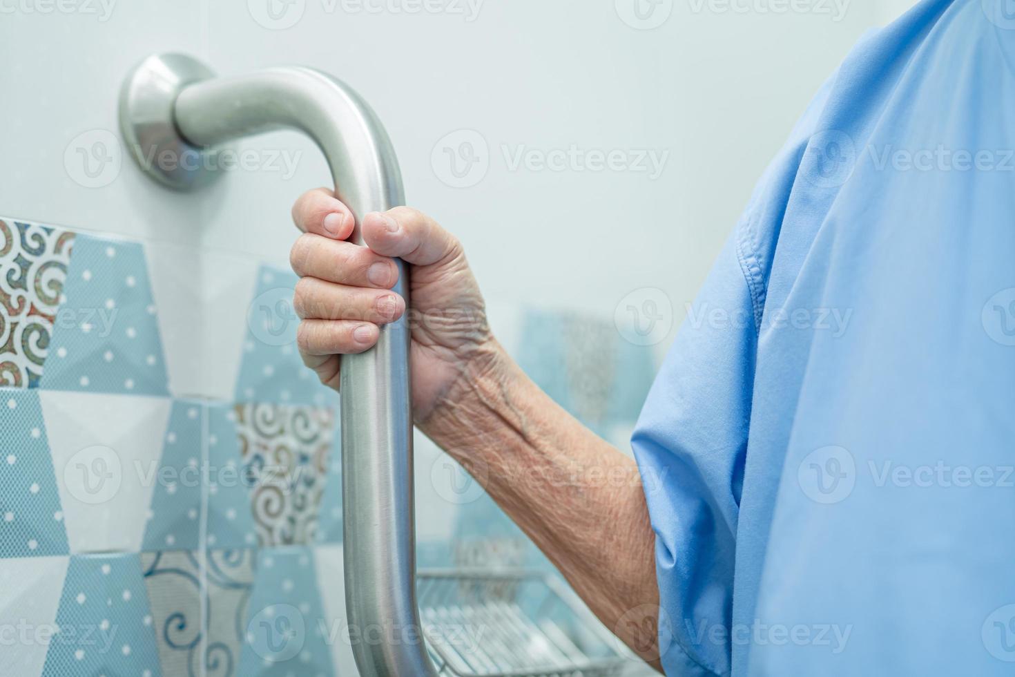 Asian senior or elderly old lady woman patient use slope walkway handle security with help support assistant in nursing hospital ward, healthy strong medical concept. healthy strong medical concept. photo