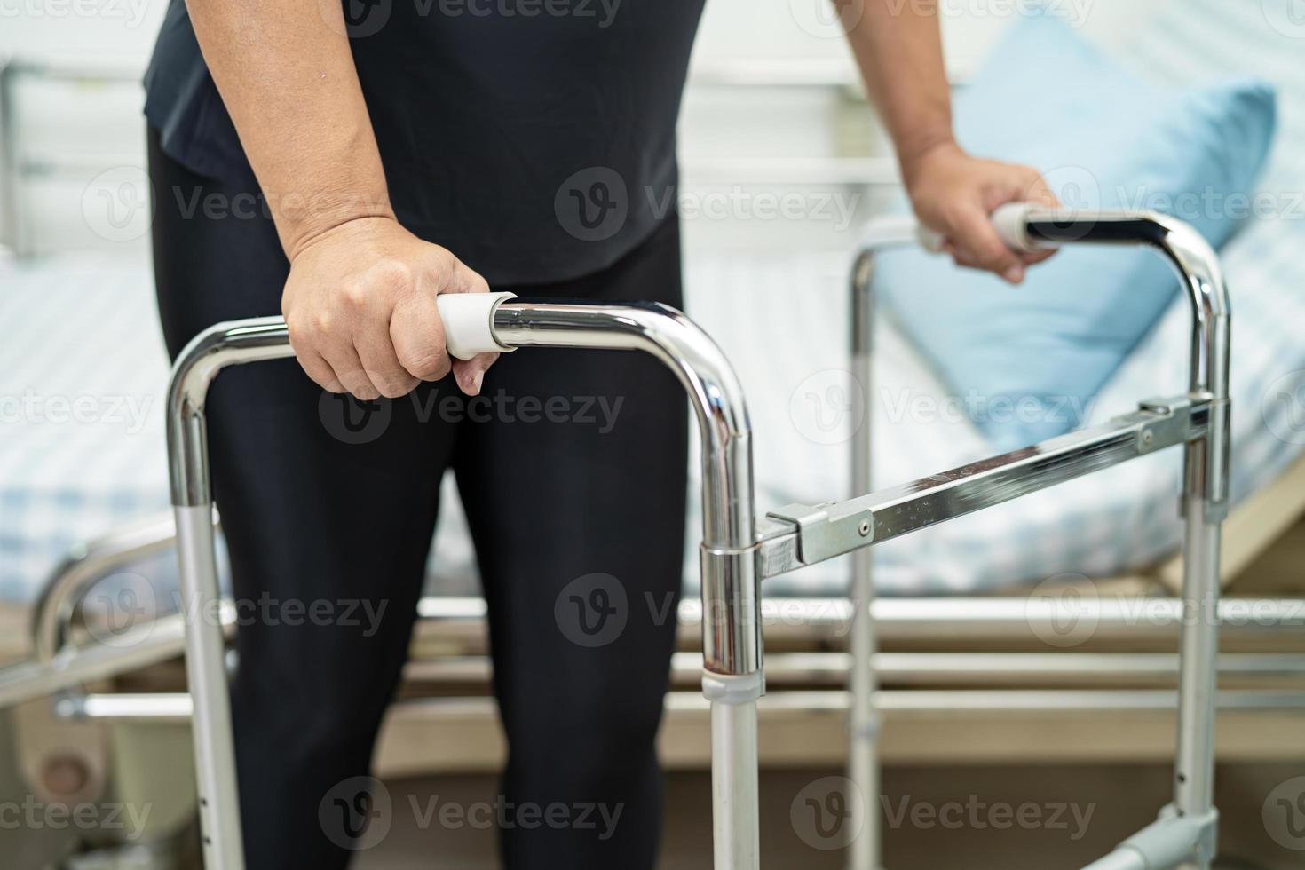 paciente asiática dama dolor de espalda, cintura, pierna y lumbar ortopédico con andador. foto