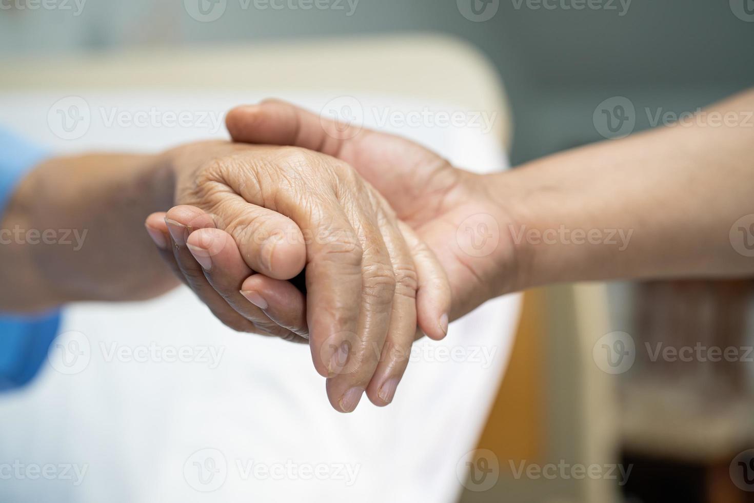 Tomados de la mano anciana asiática o anciana paciente con amor, cuidado, ánimo y empatía en la sala del hospital de enfermería, concepto médico fuerte y saludable foto