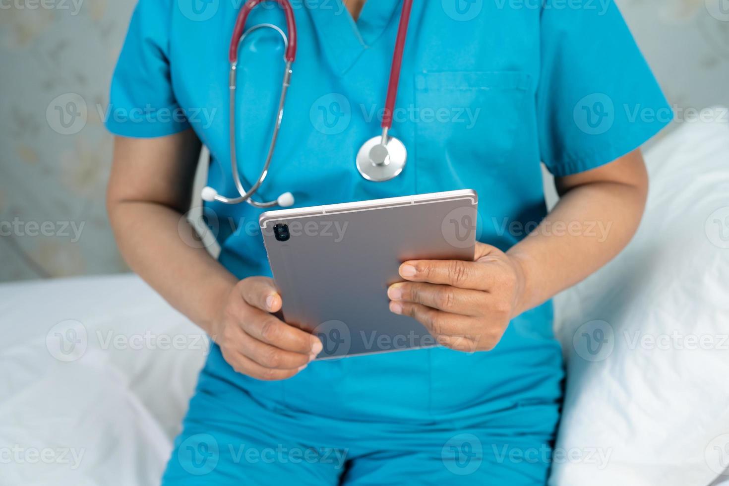 médico que sostiene la tableta digital para buscar datos para tratar al paciente en la sala del hospital de enfermería, concepto médico fuerte y saludable. foto