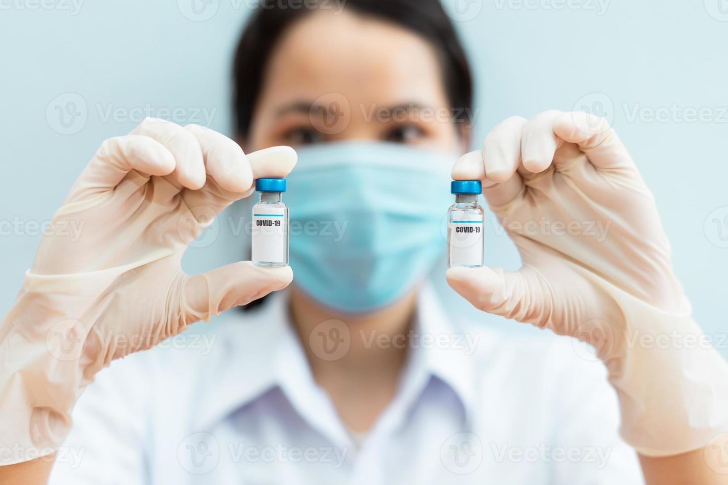 image of a female nurse holding a covid 19 vaccine photo