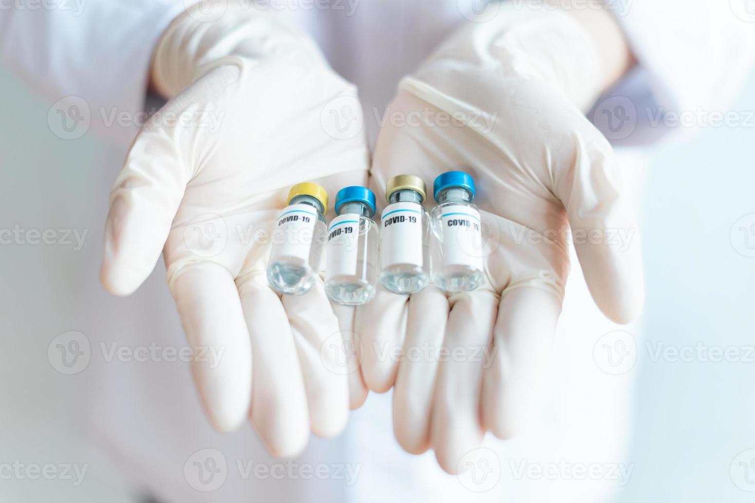 imagen de viales de vacuna en manos de enfermeras foto