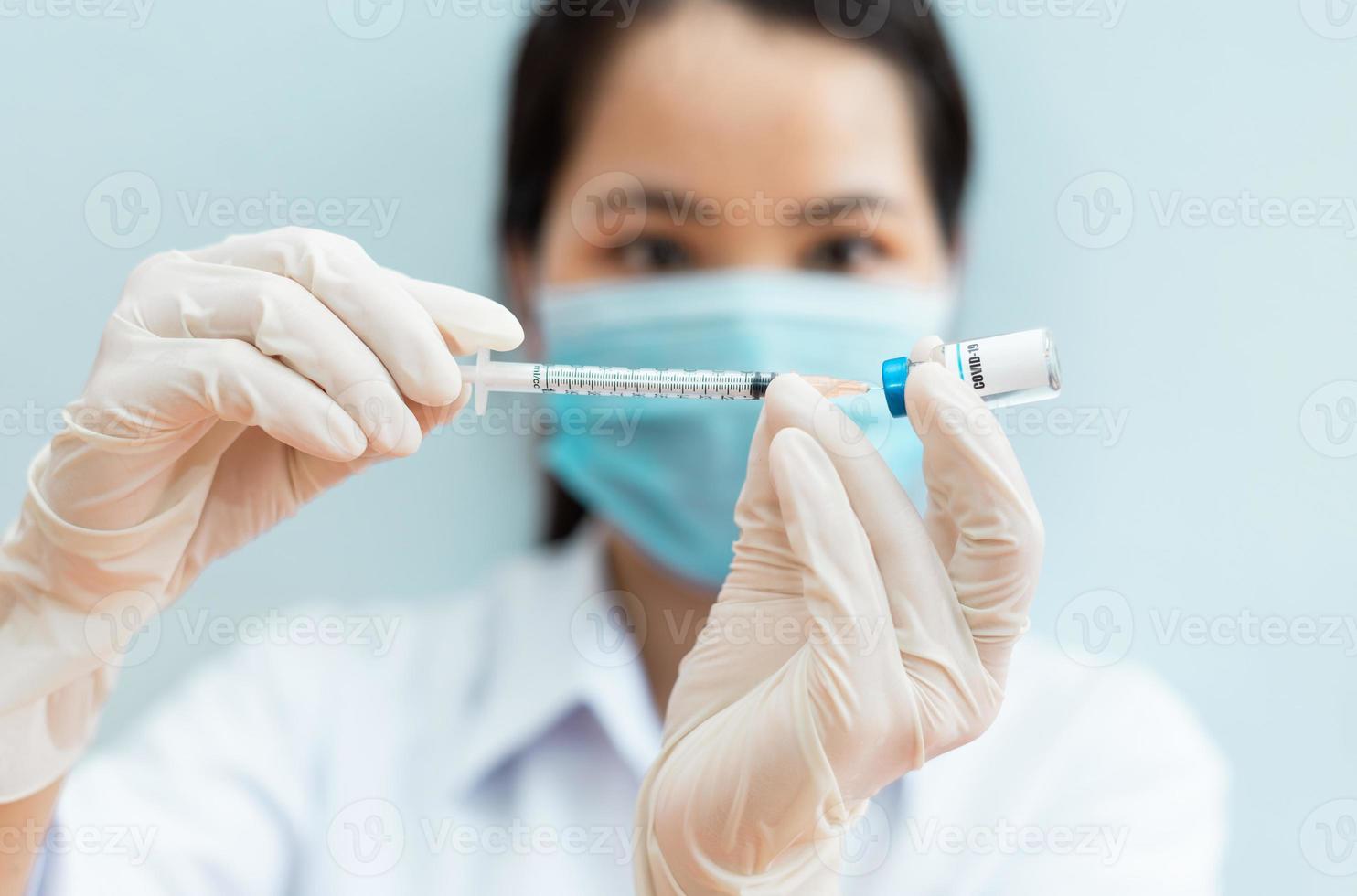 image of a female nurse holding a covid 19 vaccine photo