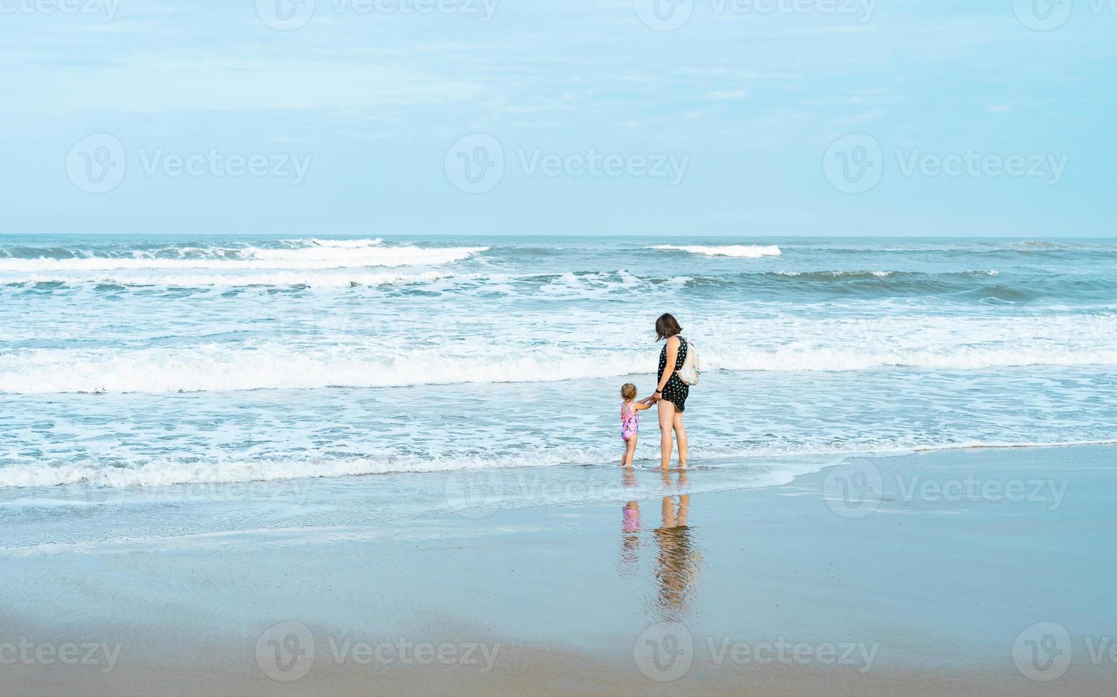 vacaciones, mamá e hija en la playa, arena, sostiene la mano foto