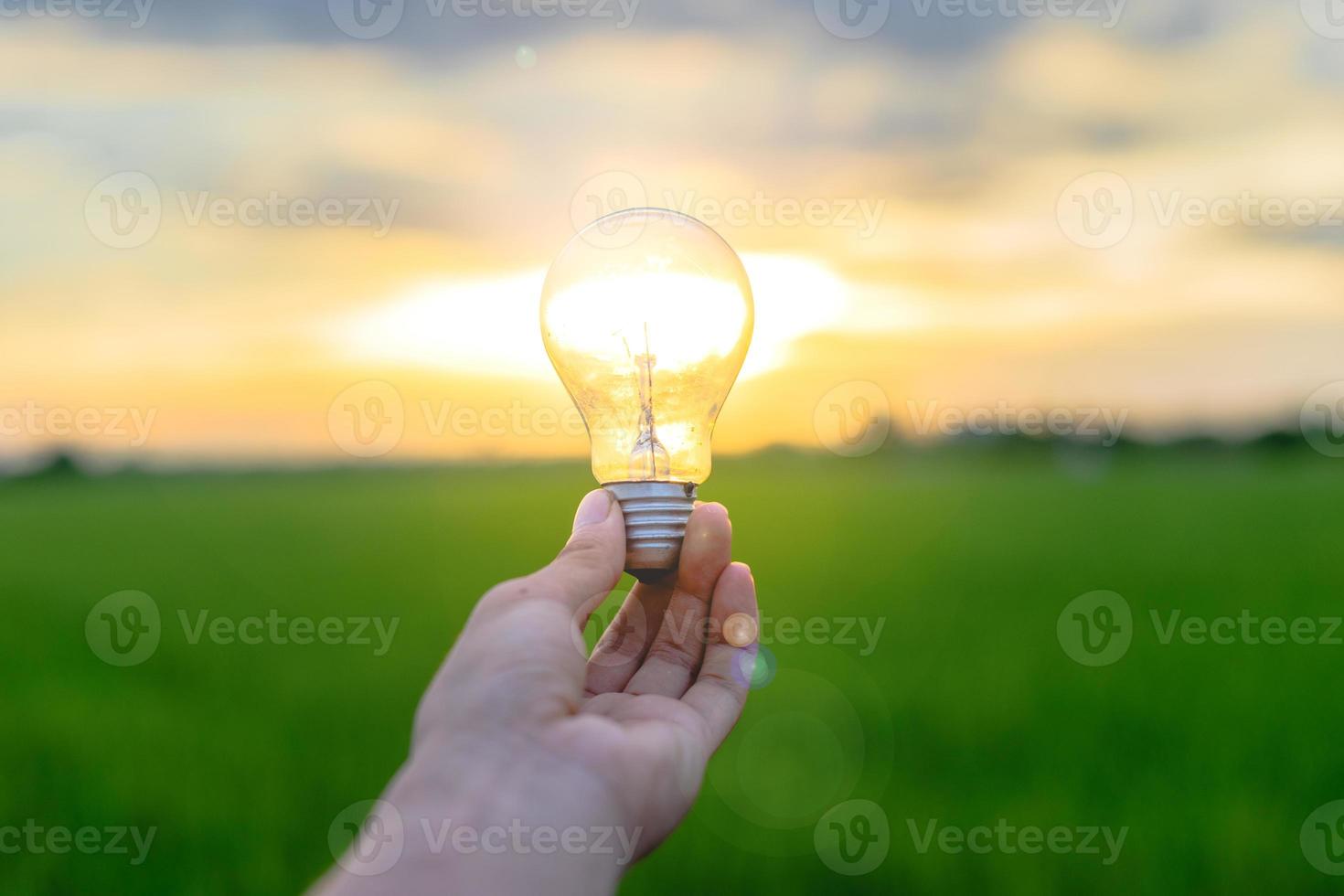 Image of a man holding a light bulb in his hand photo