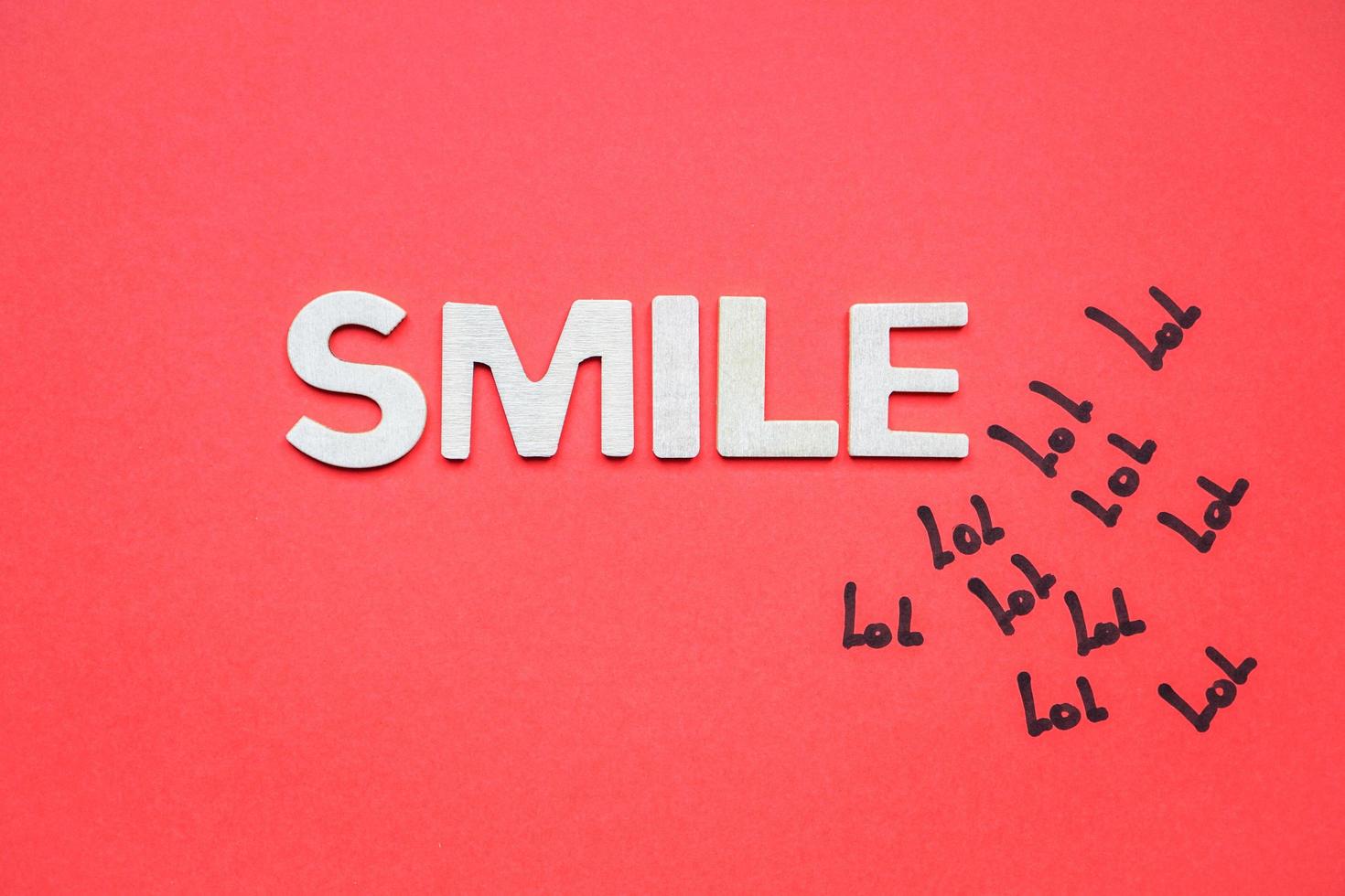 smile word with white wooden letters on the red background photo