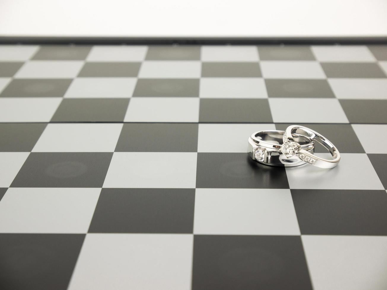 Diamond ring with king and queen chess on the board, Wedding Concept. photo