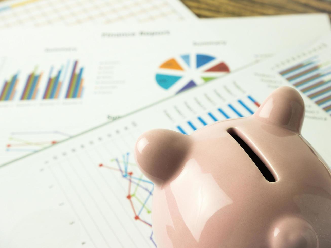 Pink piggy bank on business graph, finances and economy concept photo