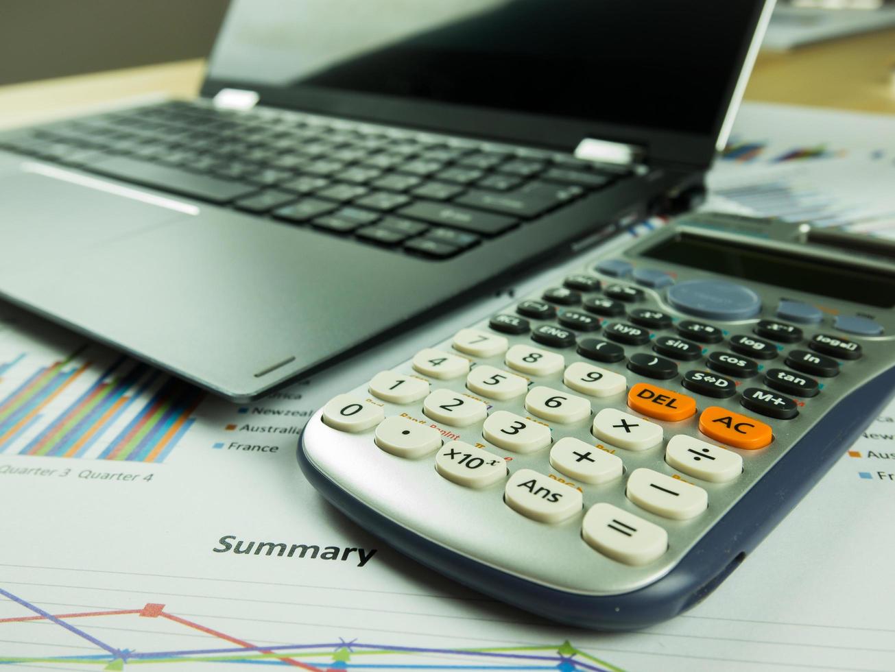 Business report chart and Financial graph analysis with notebook and calculator on the table photo