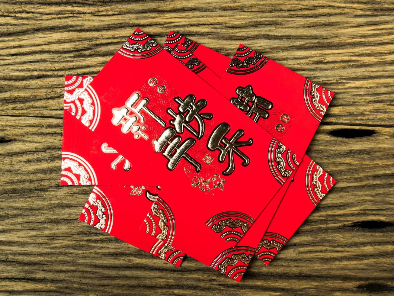 Sobre rojo sobre fondo de madera con febrero para regalo año nuevo chino. texto chino en el sobre que significa feliz año nuevo chino foto