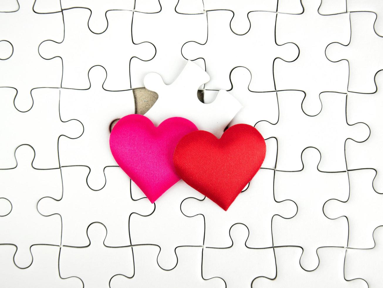 Colorful mini hearts on jigsaw puzzle pieces background, Valentine decorations, Various hearts photo