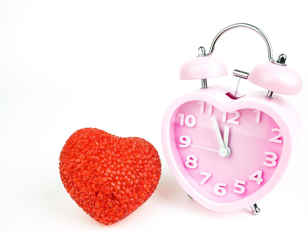 Pink alarm clock in the form of heart isolated on white background, Valentine's Day photo
