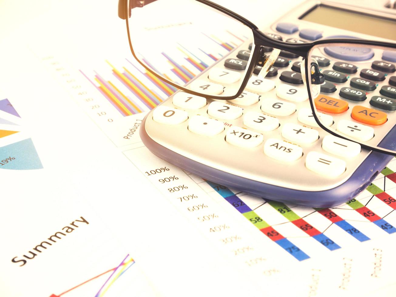 Business chart near calculator by unfocused glasses, Financial concept photo