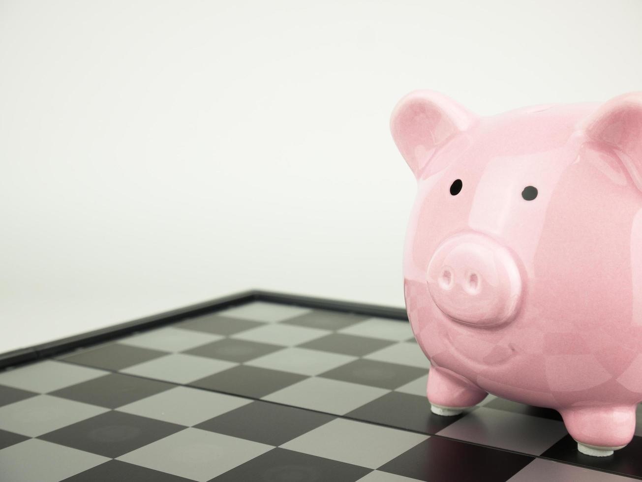Pink piggy bank on chess board photo