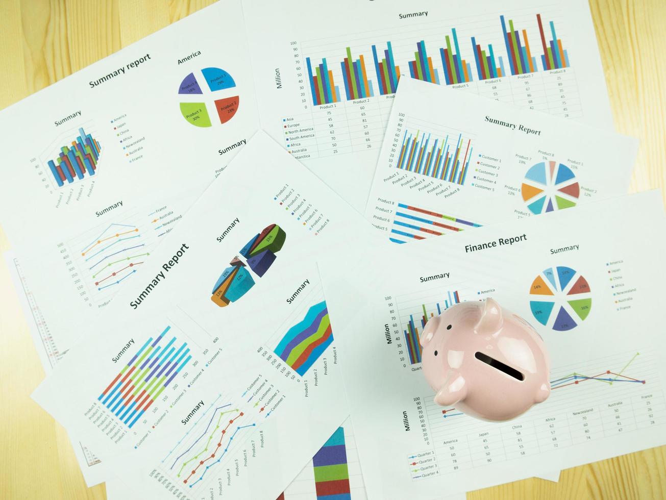 Gráfico de informe comercial y análisis de gráfico financiero con hucha rosa sobre la mesa, concepto de economía foto