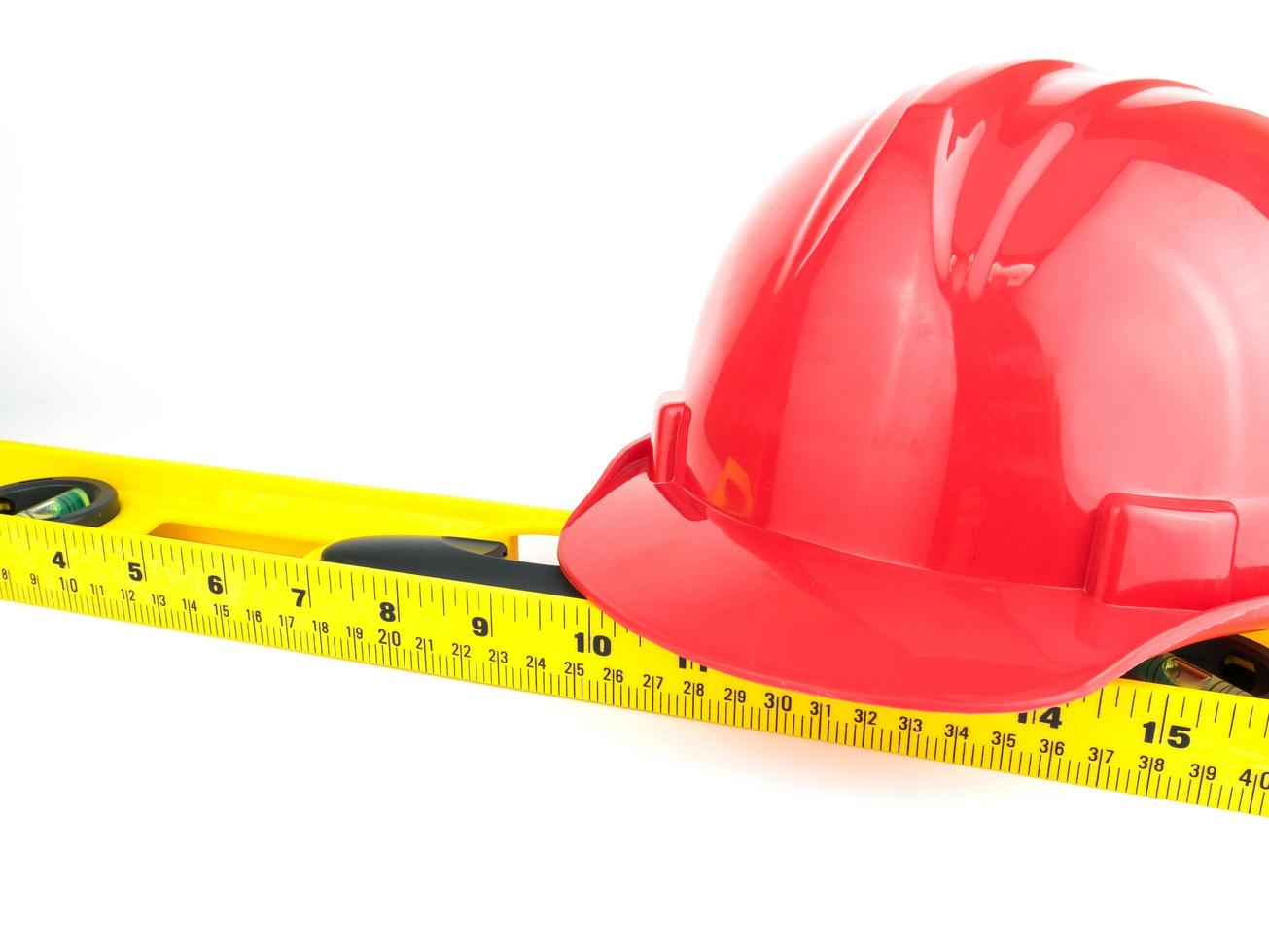 Red safety helmet and Balance ruler on white background, Engineering construction concept photo