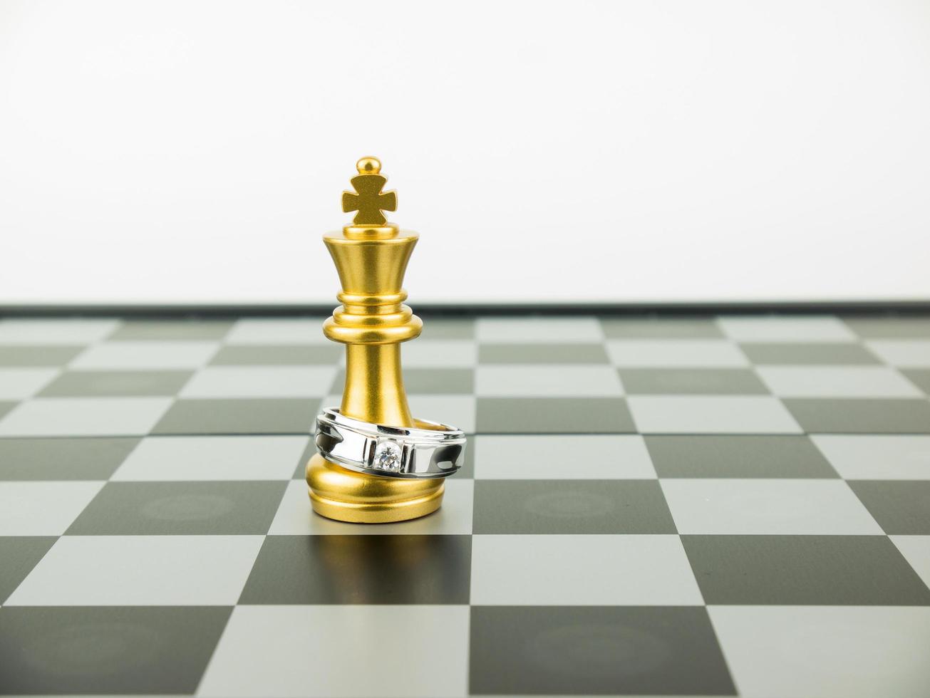 Diamond ring with king chess piece on the board, Wedding Concept photo