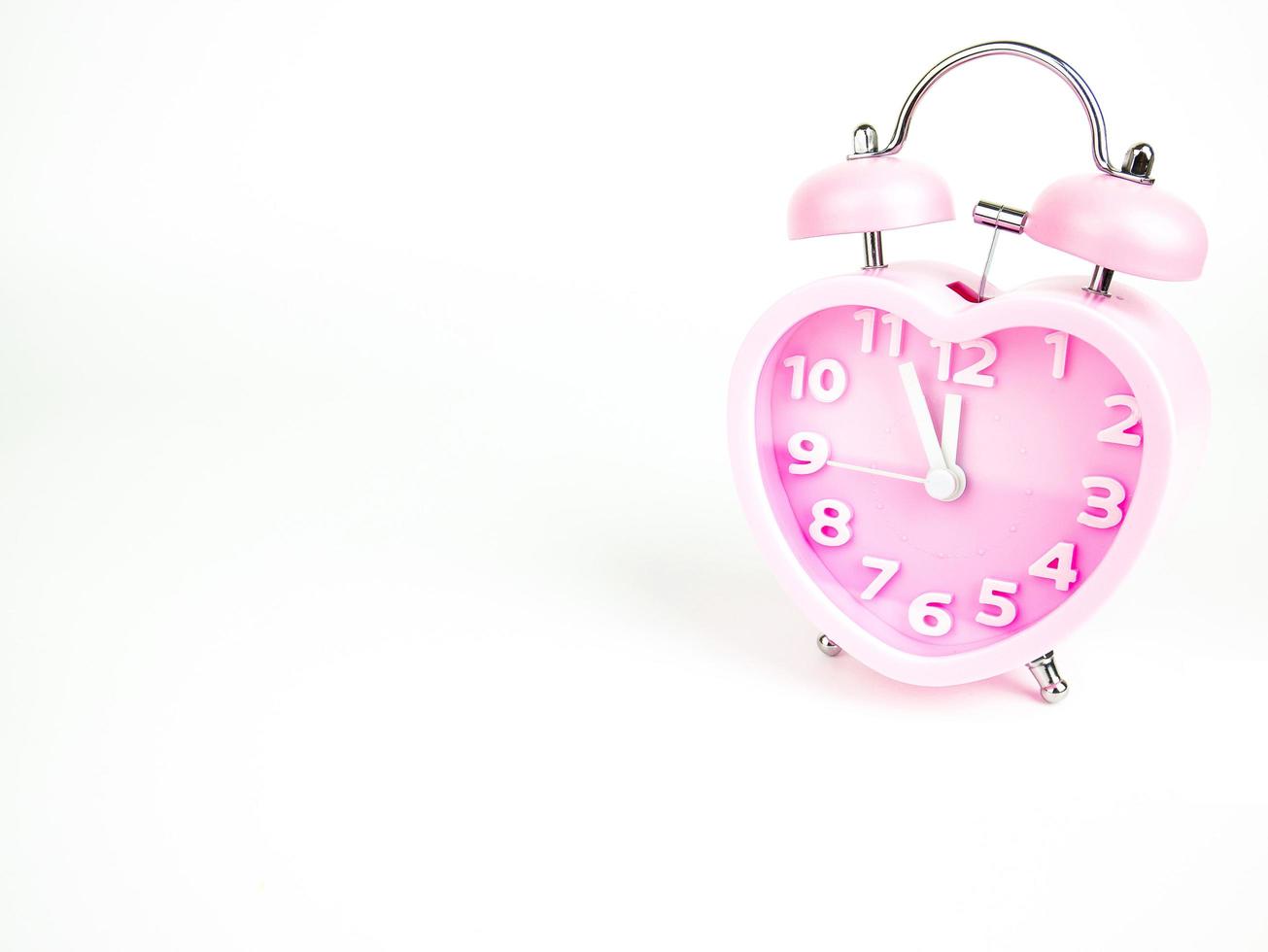 Pink alarm clock in the form of heart isolated on white background, Valentine's Day photo